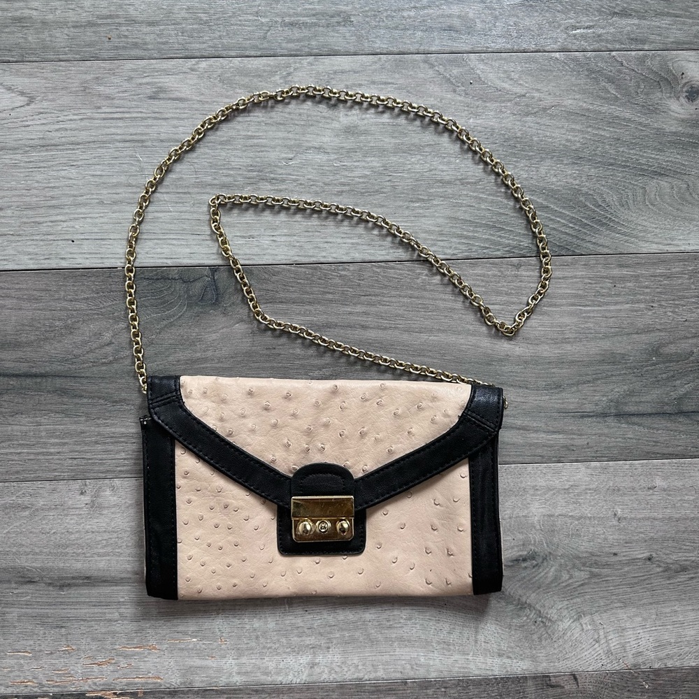 Nude clutch with gold chain.